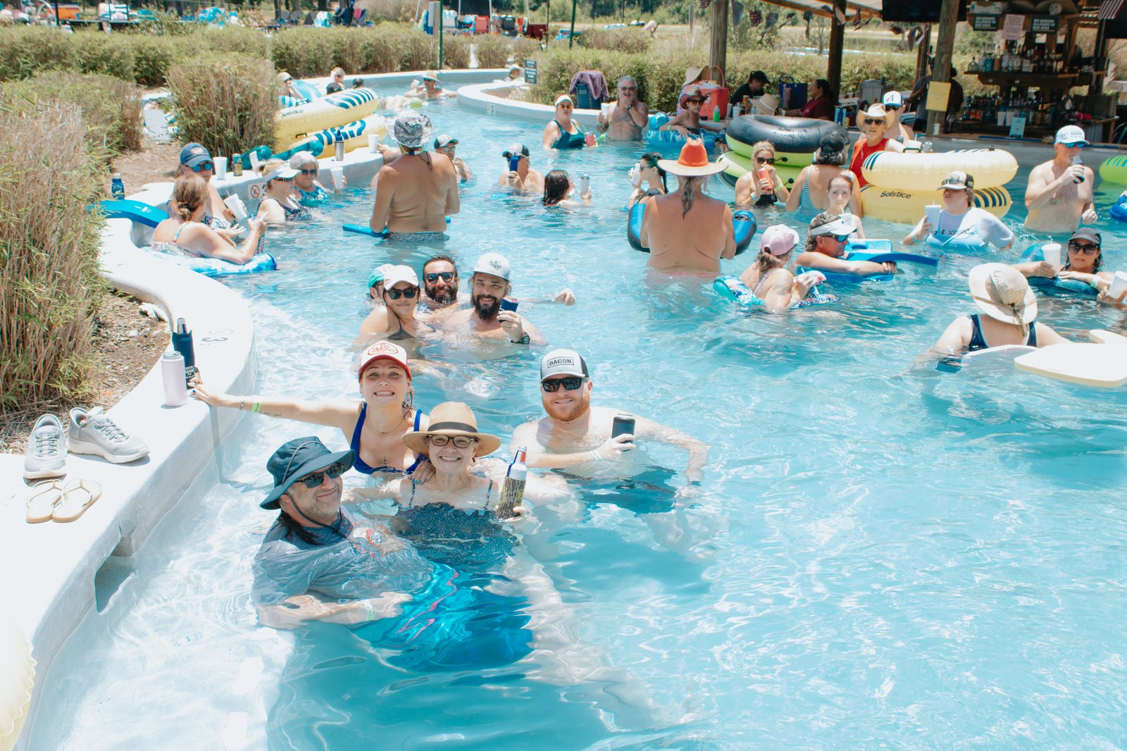 Campers floating and relaxing in the lazy river on a sunny summer day
