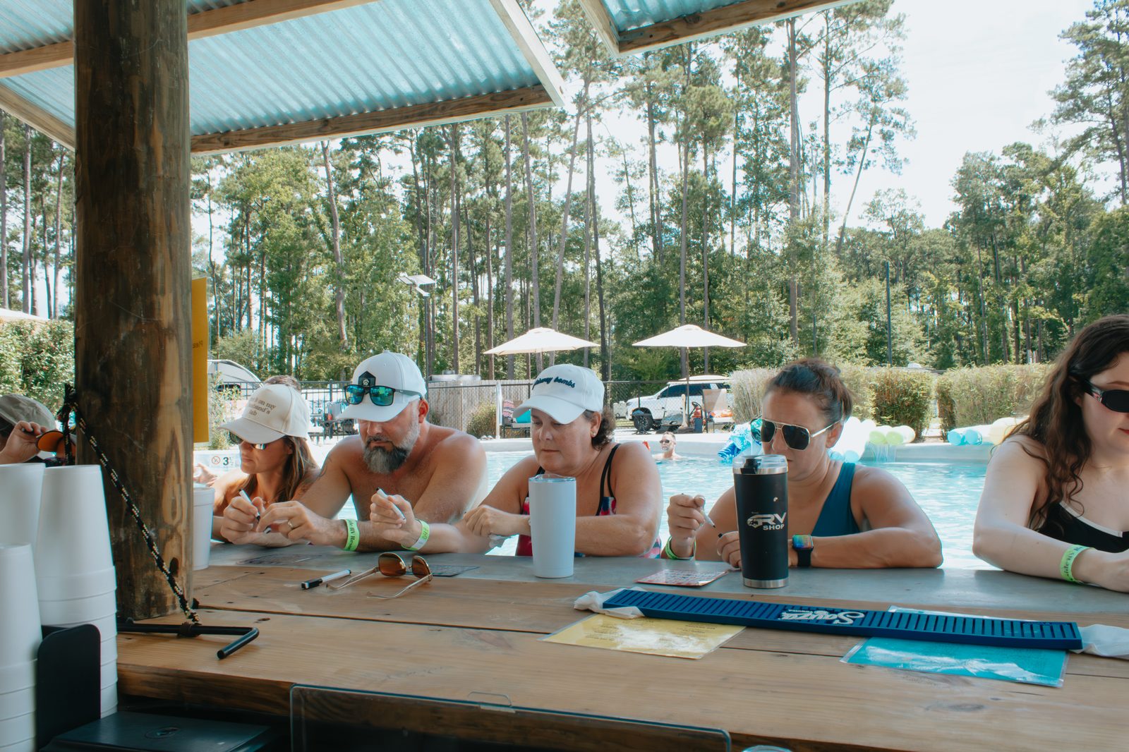 Guests relaxing at the poolside swim-up bar at Fireside RV Resort on a sunny summer day